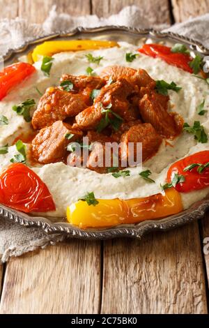 https://l450v.alamy.com/450v/2c75bk0/alinazik-kebab-is-a-home-style-turkish-dish-which-is-a-specialty-of-the-gaziantep-province-of-turkey-closeup-in-the-plate-on-the-table-vertical-2c75bk0.jpg