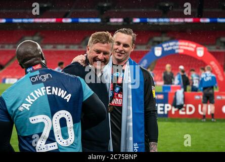 London, UK. 13th July, 2020. Goalkeeper David Stockdale (on loan from Birmingham City) & Adebayo Akinfenwa of Wycombe Wanderers with Oxford United manager Karl Robinson at full time during the Sky Bet League 1 play-off final match between Oxford United and Wycombe Wanderers played behind closed doors due to government restrictions on football during the worldwide Covid-19 pandemic, match played at Wembley Stadium, London, England on 13 July 2020. Photo by Andy Rowland. Credit: PRiME Media Images/Alamy Live News Stock Photo