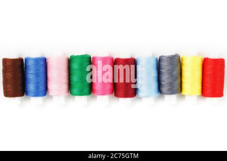Colorful cotton craft sewing threads multicolored in a row isolated on a white background. Stock Photo