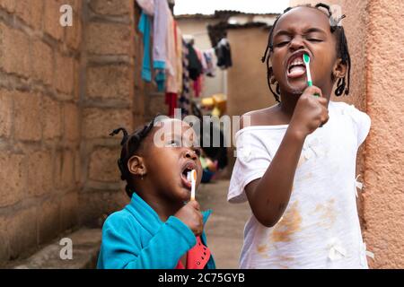 Barbie and Amilia brushing their teeth before having their breakfast. Kids are home due to the Coronavirus. Karugira, Kigali, Rwanda. Stock Photo
