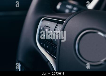 close up Modern black steering wheel with multifunction buttons Integrated stereo controls pushes the for quick control technology in the car. Stock Photo