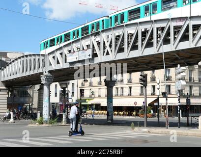 Paris, France. July 11. 2020. Two men on an electric scooter passing under the Bercy Bridge in the tourist district. An eco-friendly and economical. Stock Photo