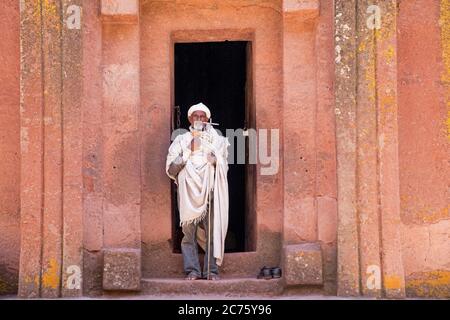 Priest leaving the Biete Gabriel-Rufael / Beta Gabriel Rafael church, underground monolith church in Lalibela, Lasta Amhara Region, Ethiopia, Africa Stock Photo