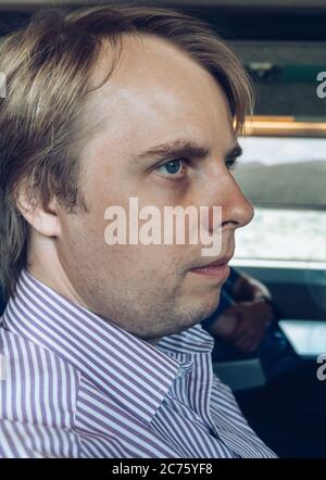 close up portrait of blond white man sitting in the train Stock Photo