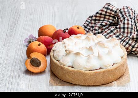 Tasty  meringue pie with fresh apricot on wooden table Stock Photo
