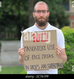 Parliament Square, London, UK. 14th July, 2020. A lone protester with placard demonstrates against the mandatory use of face masks in shops and supermarkets on Parliament Square this afternoon. Masks wearing is to be made compulsory in shops and supermarkets from July 24th. Credit: Imageplotter/Alamy Live News Stock Photo