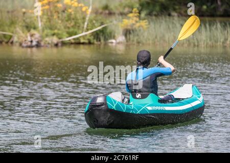 man in neoprene kayaking on a lake Stock Photo