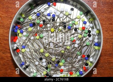 Close up view on lots of sewing pins with colored heads in a metal box Stock Photo