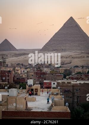 children playing on a rooftop in egypt in front of the pyraids of Giza Stock Photo