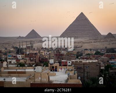 children playing on a rooftop in egypt in front of the pyramids of Giza Stock Photo