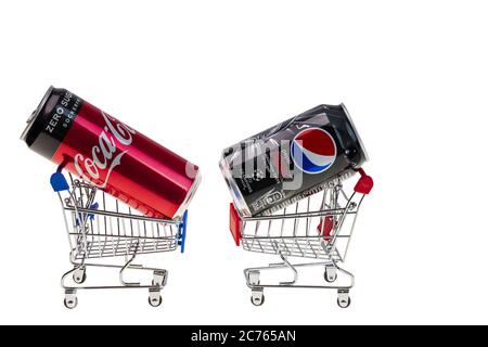 Close up view of coca and pepsi cola can in shopping carts on white background isolated. Unhealthy drinks concept. Stock Photo