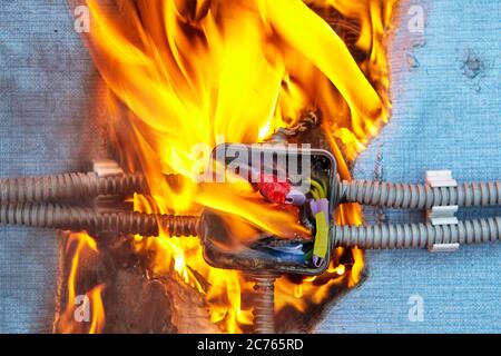 Electric fire caused by a short circuit in home electrical network. Damaged wiring caused overload of power system in house. Burned insulation of the Stock Photo