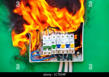 Short circuit and overload in circuit breakers led to electrical fire. Ignition hazard when using faulty wires in a home electric system. Burning swit Stock Photo