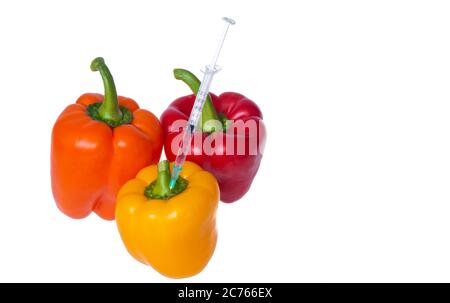 Genetically modified vegetables. GMO food concept. Syringes are stuck in vegetables with chemical additives. Injections into fruits and vegetables. Is Stock Photo