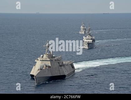 The U.S. Navy Independence-variant littoral combat ship USS Gabrielle Giffords, left, during a joint patrol with the Japan Maritime Self-Defense Kashima class cadet training ship JS Kashima and Force Hatsuyuki-class destroyer JS Shimayuki in International Waters June 23, 2020 in the South China Sea. Stock Photo