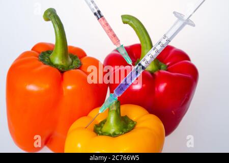 Genetically modified vegetables. GMO food concept. Syringes are stuck in vegetables with chemical additives. Injections into fruits and vegetables. Is Stock Photo