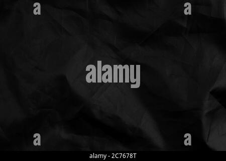 Abstract black synthetic material with wrinkles and wrinkled folds. Old wrapping dusty cloth. Crumpled dramatic texture background. For design and hea Stock Photo