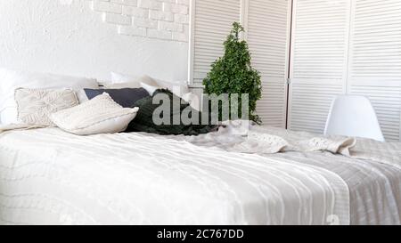 Unmade bed in modern bedroom. From above warm blanket and soft pillows placed on comfortable unmade bed in stylish contemporary bedroom Stock Photo