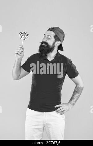 Nutritional values. Calories and vitamin. Homemade caramel candy. Sweets addicted. Hipster lollipop candy. Taste of childhood. Eating sweets. Man eat lollipop sweets. Having fun carefree man. Stock Photo