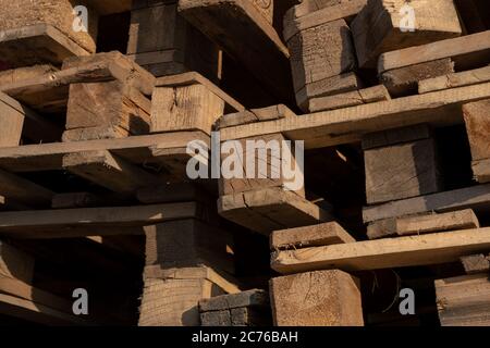 Wooden euro pallets for transfering goods to customers. Used wooden pallets in stack in the warehouse. Wooden pallet overlap. Stock Photo