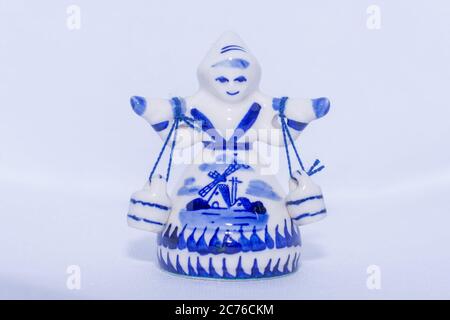 Delft Blue Figurine of girl carrying bells. Souvenir from Holland/Netherlands on isolated white background. Stock Photo