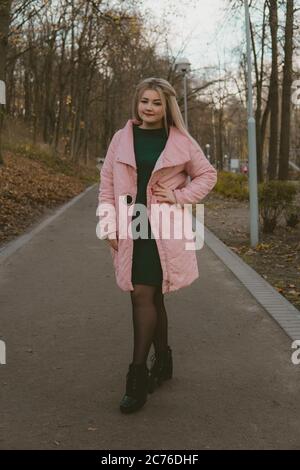 A beautiful girl walks along the alley in the autumn park. Stock Photo