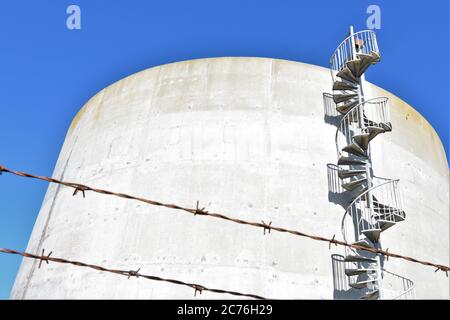 Spiral stairs on the side of a water tank in San Francisco for drinking water made of concrete and is round on Buena Vista island in the bay Stock Photo