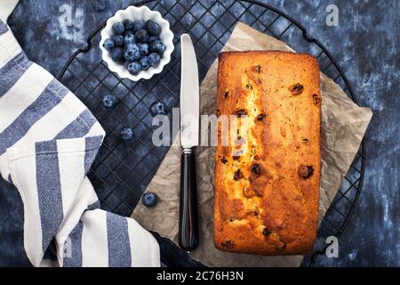 Delicious homemade cottage cheese and raisins loaf cake on blue background, top view Stock Photo