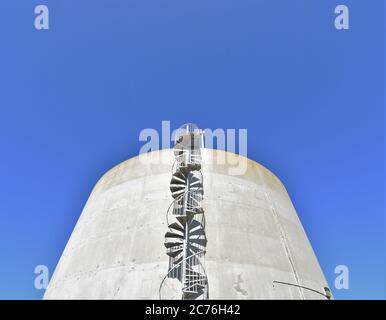 Spiral stairs on the side of a water tank in San Francisco for drinking water made of concrete and is round on Buena Vista island in the bay Stock Photo