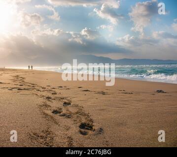 couple leaving foot prints in sandy beach Stock Photo - Alamy