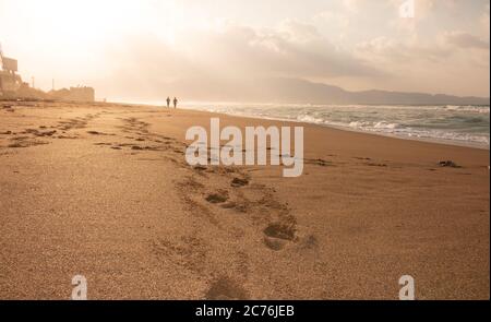 couple leaving foot prints in sandy beach Stock Photo - Alamy