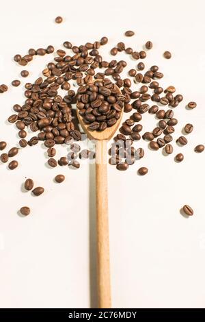 coffee beans and wooden spoon isolated on white background Stock Photo