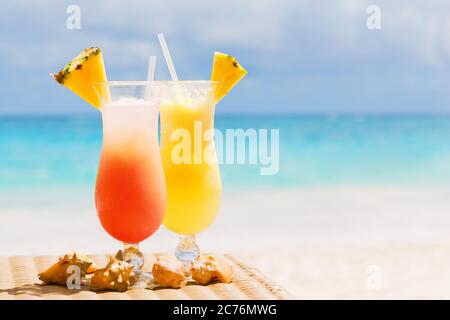 Two tropical fresh juices on white sandy beach Stock Photo