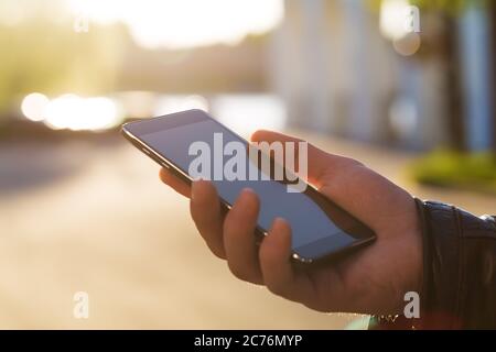 Man using his Mobile Phone outdoor, close up Stock Photo