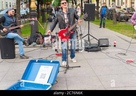 SAINT PETERSBURG, RUSSIA - JULY 11, 2019: Musicians perform on a street of St. Petersburg. Putin portrait on a t-short of a singer Stock Photo