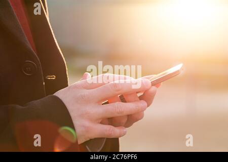 Man using his Mobile Phone outdoor, close up Stock Photo