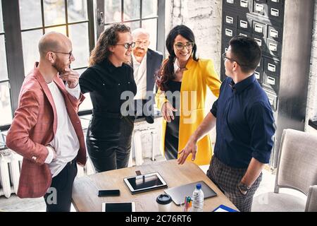 Happy colleagues having fun during working process collaborating in friendly atmosphere, cheerful colleagues satisfied with completing successful Stock Photo