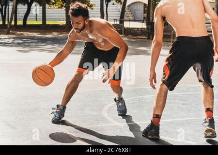 young man playing basketball dribbles his opponent Stock Photo