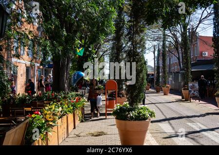 The narrow sidewalk surrounded by green vegetation, flowers and plants in vases in front of Casa Bela - Cafe and Restaurant at Doria Vasconcelos stree Stock Photo