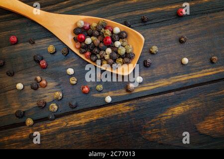 Spice. Mix of peppers in a wooden spoon, on a wooden table. top view. Flat lay. Food concept. Stock Photo