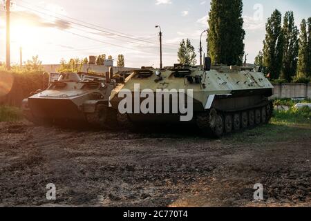 Old Russian armored vehicles on sunset background at military base Stock Photo