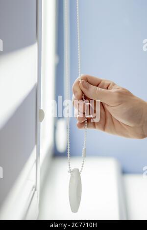 Man testing cassette roller blinds on windows. Stock Photo