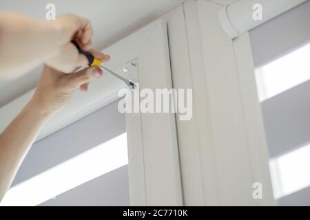 Man installing cassette roller blinds on windows Stock Photo