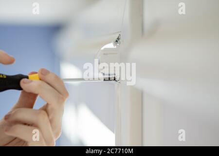 Man installing cassette roller blinds on windows Stock Photo