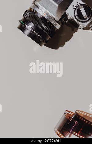 Geometric Flat lay set: vintage camera on light backgrounds with 35 mm filmstrip. Top view. Stock Photo