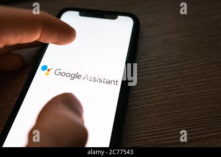 Smartphone with google assistant logo on the screen. Stock Photo