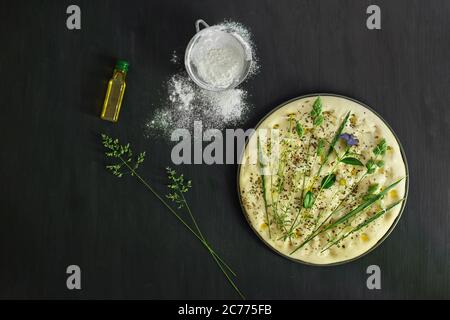 Preparing a garden flatbread with wildflowers, grasses and herbs Stock Photo