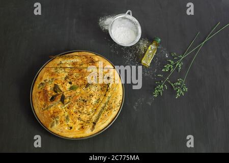 Freshly baked garden flatbread with wildflowers, grasses and herbs Stock Photo
