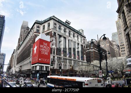 Looking at Macy's Department Store from the intersection at 34th street an 6th Avenue, Herald Square. Traffic, a bus and pedestrians are in shot. Stock Photo