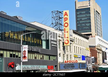 The red and yellow advertising sign and marquee for the Apollo Theatre in Harlem, New York City. A Banana Republic and Red Lobster are next door. Stock Photo